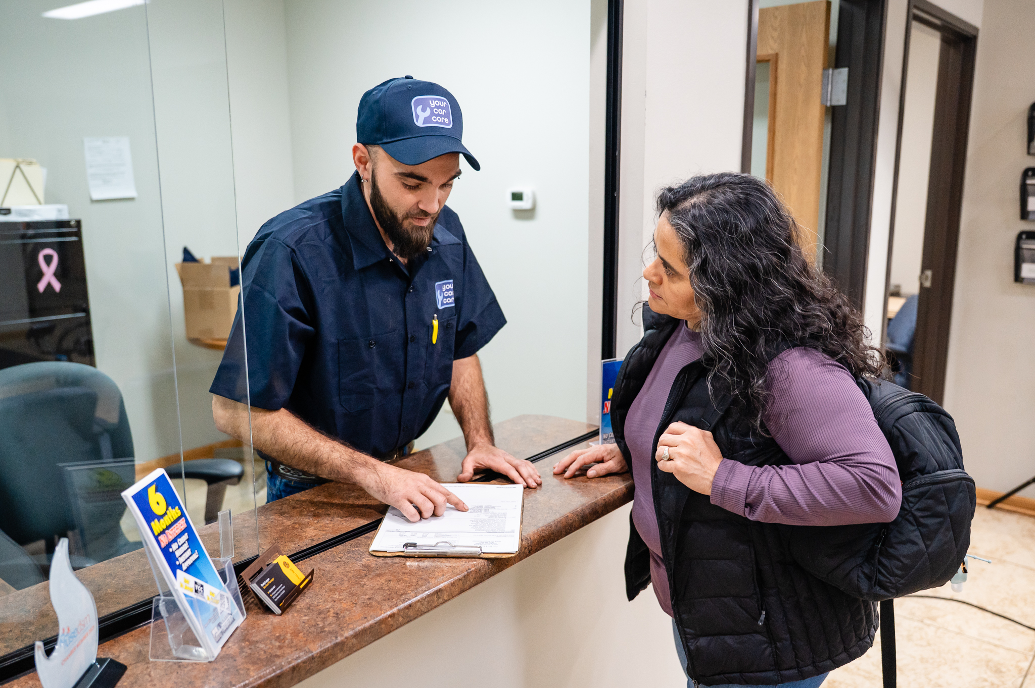 YCC technician explaining services to a customer at the desk