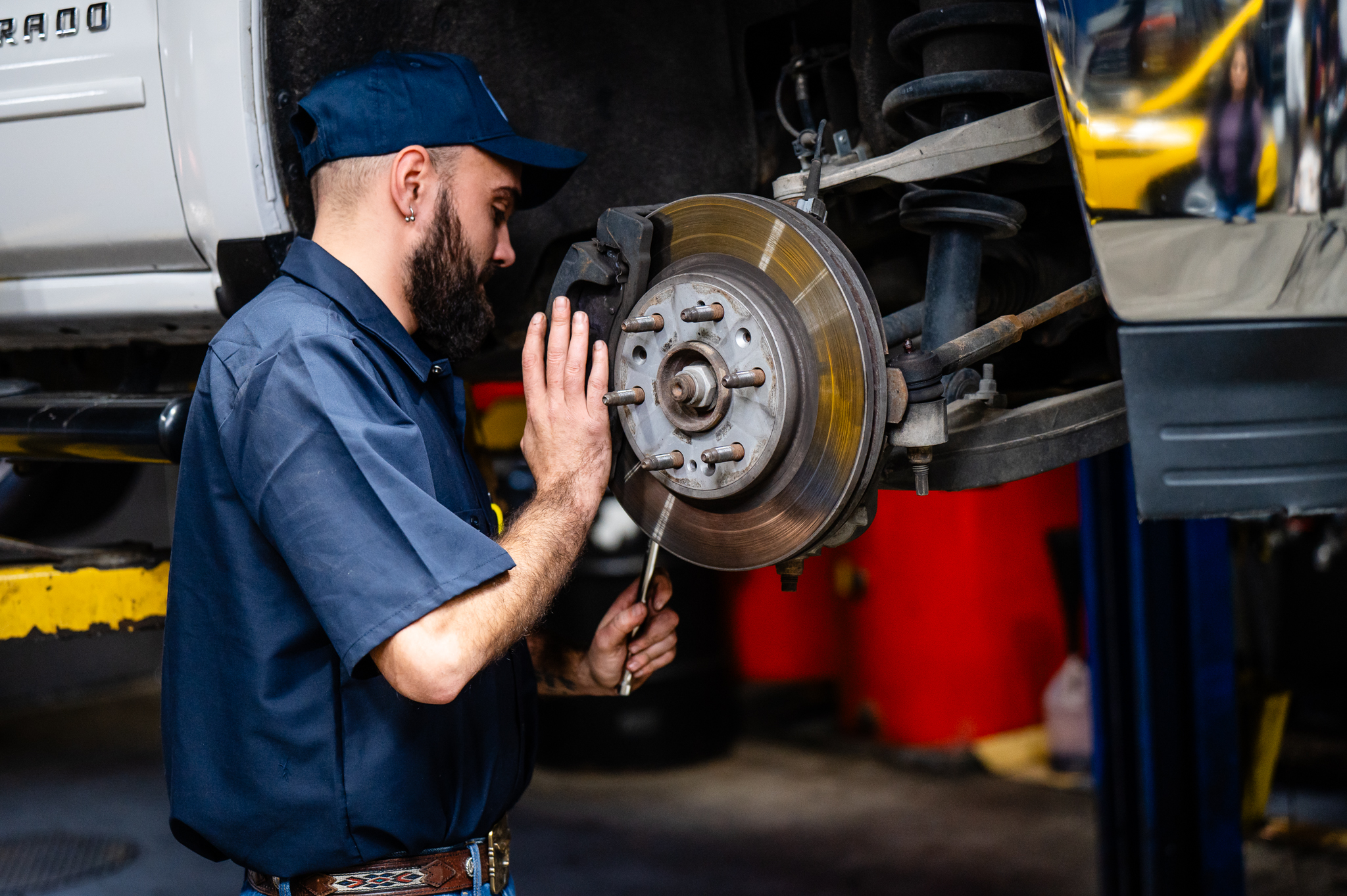 Technician using a torque wrench to secure lug nuts on a vehicle's wheel
