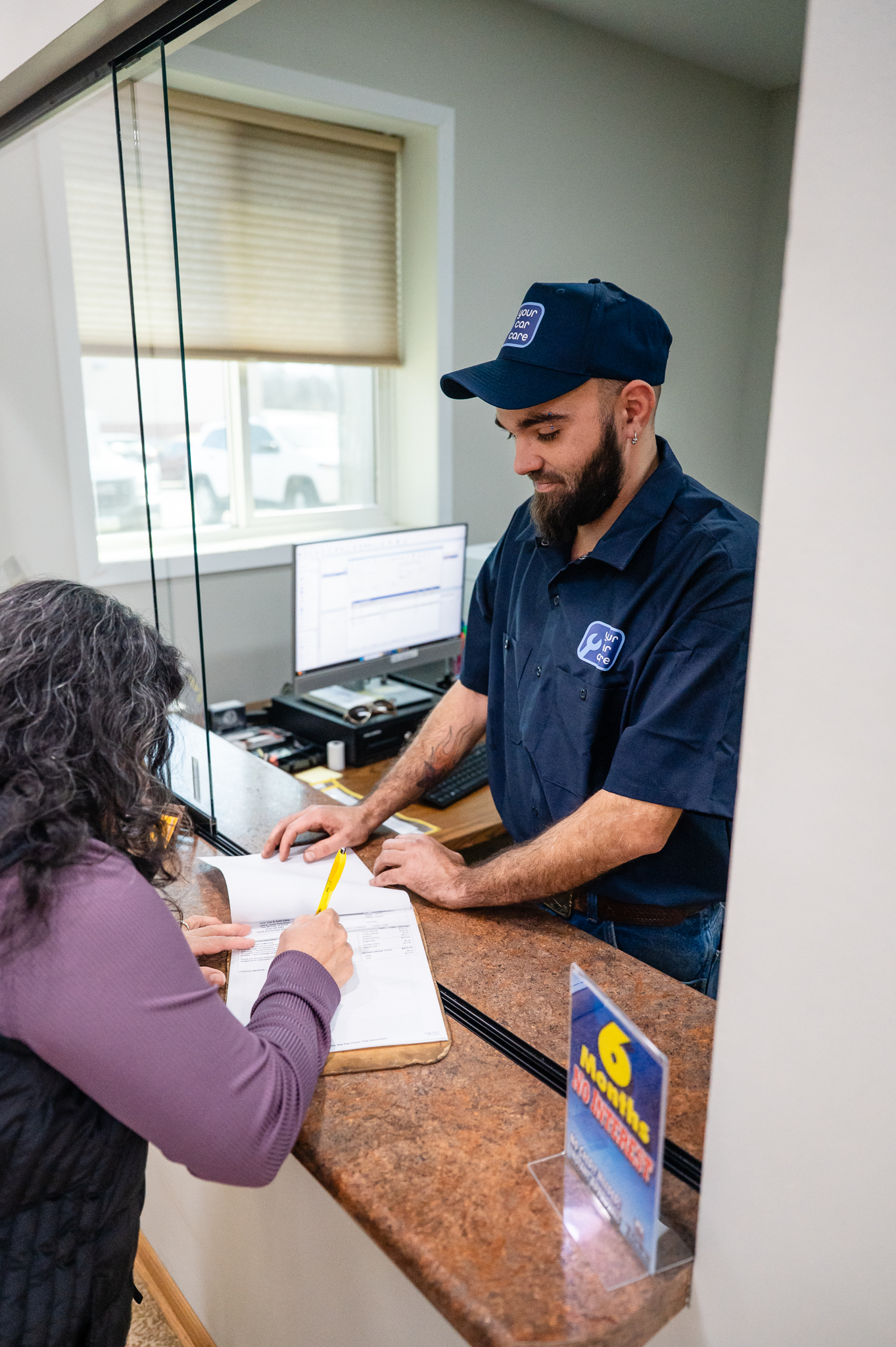 Your Car Care auto technician preparing client for payment at service desk