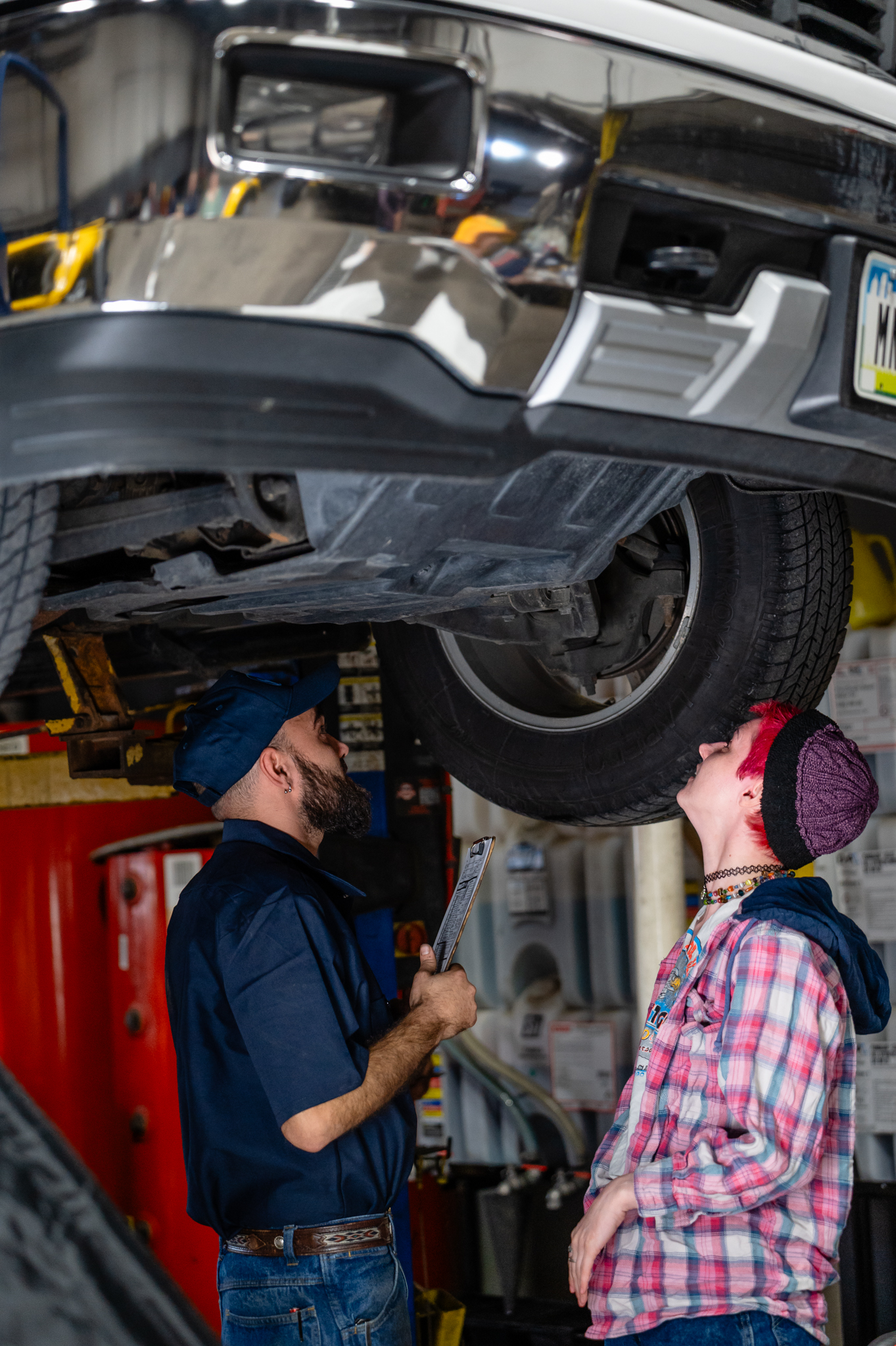 Auto technician beneath car while servicing a customer's vehicle