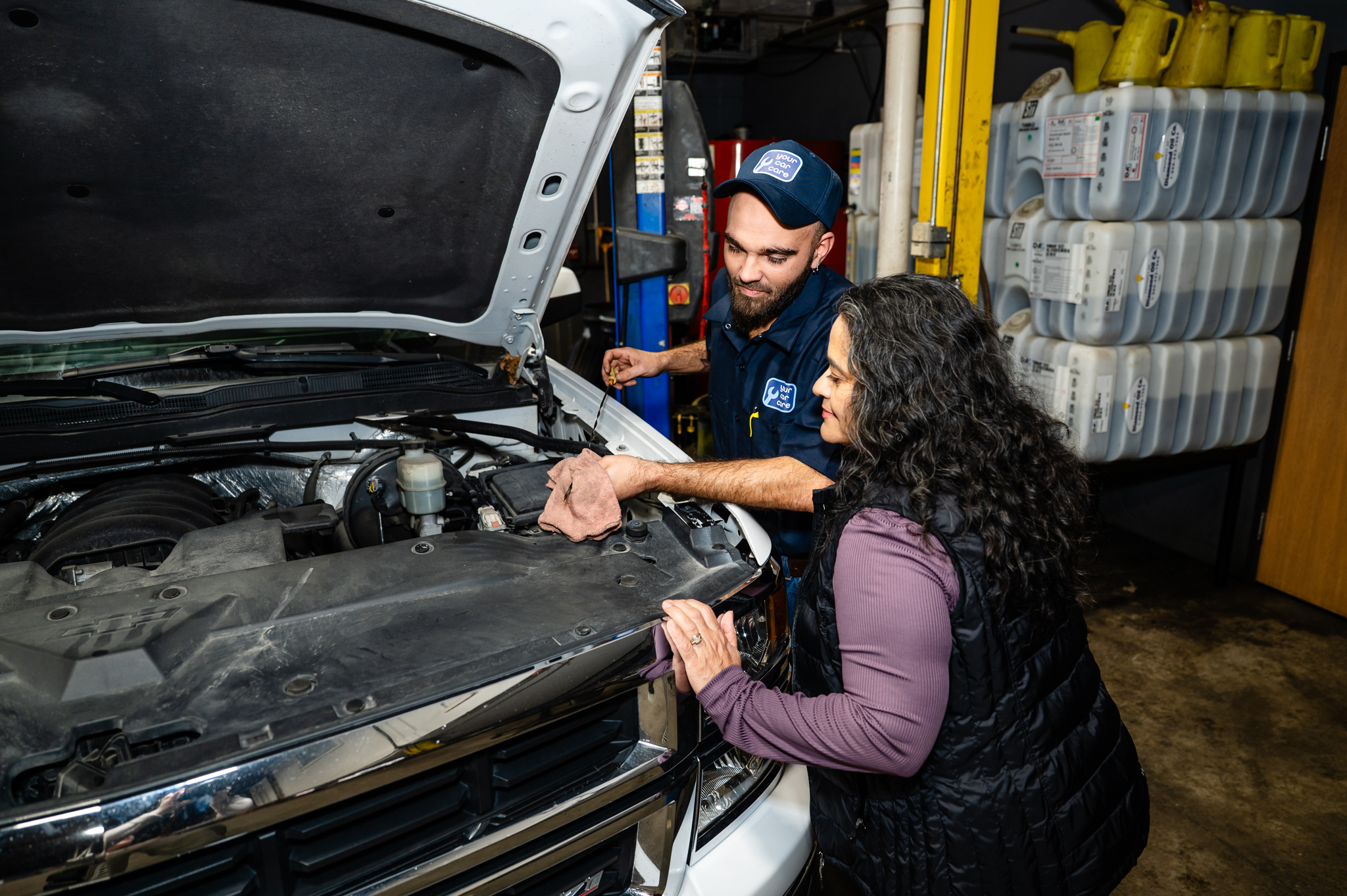 YCC technician explaining services to a customer while checking her vehicle