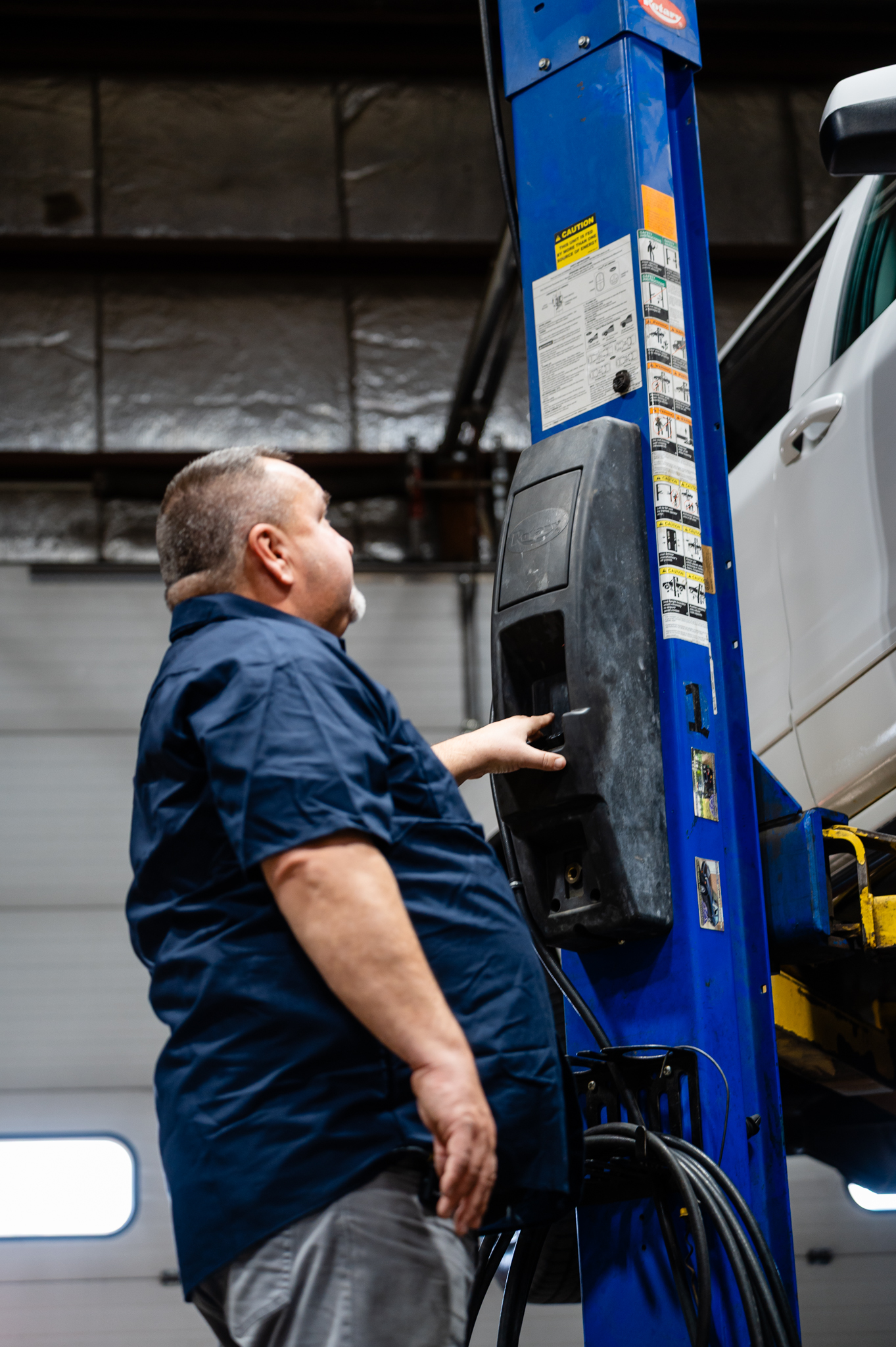 YCC technician using lift to inspect a vehicle