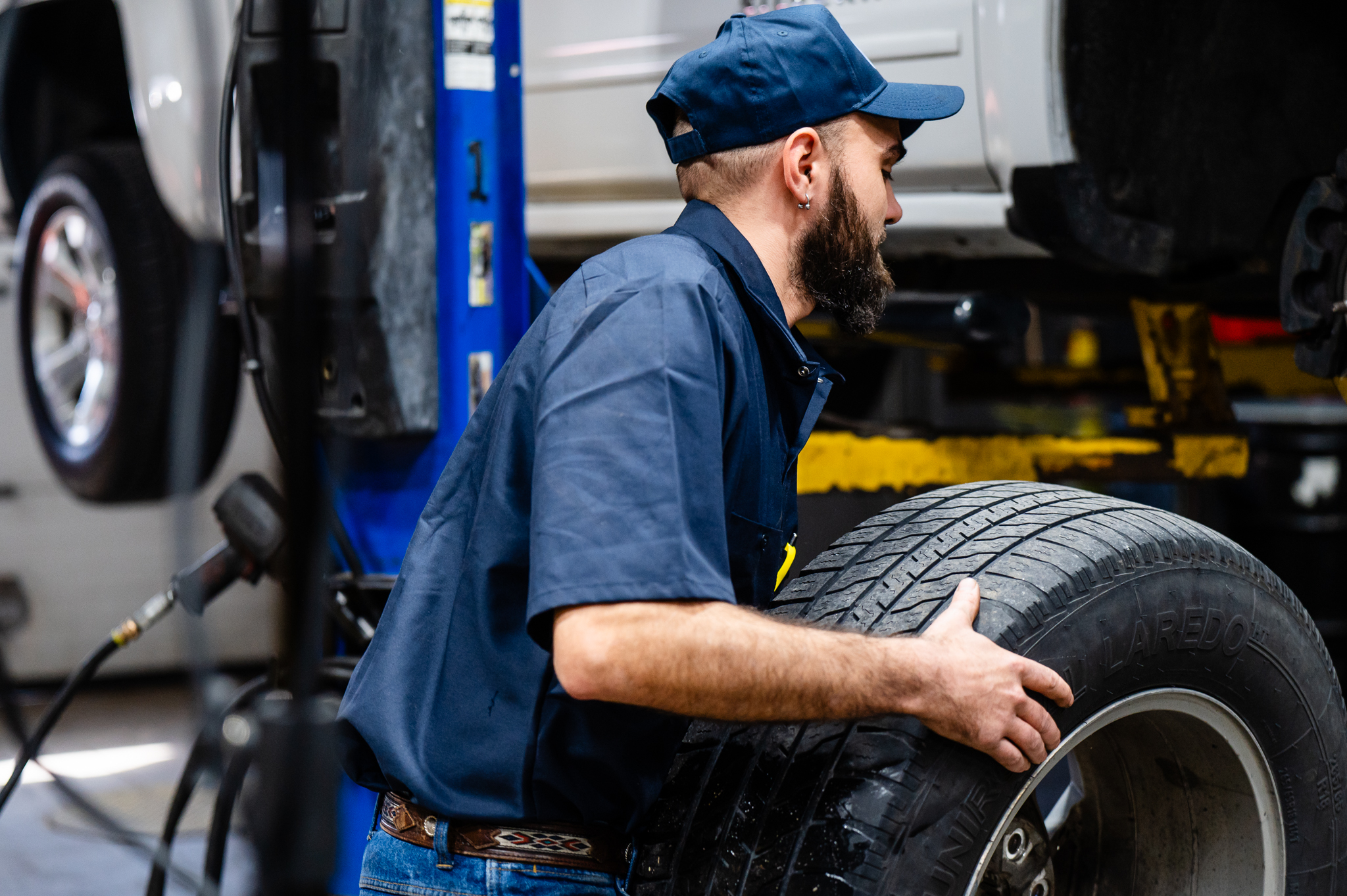 Technician inspecting tires at Des Moines auto shop | Tire rotation in progress