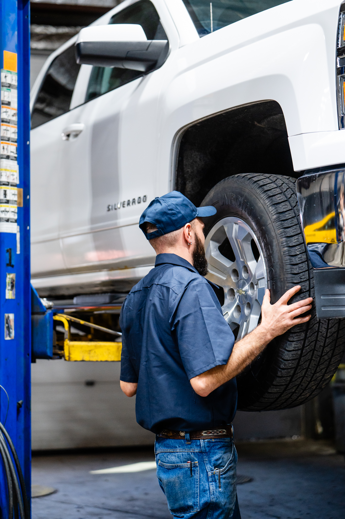 Tire technician replacing tires on a pickup truck